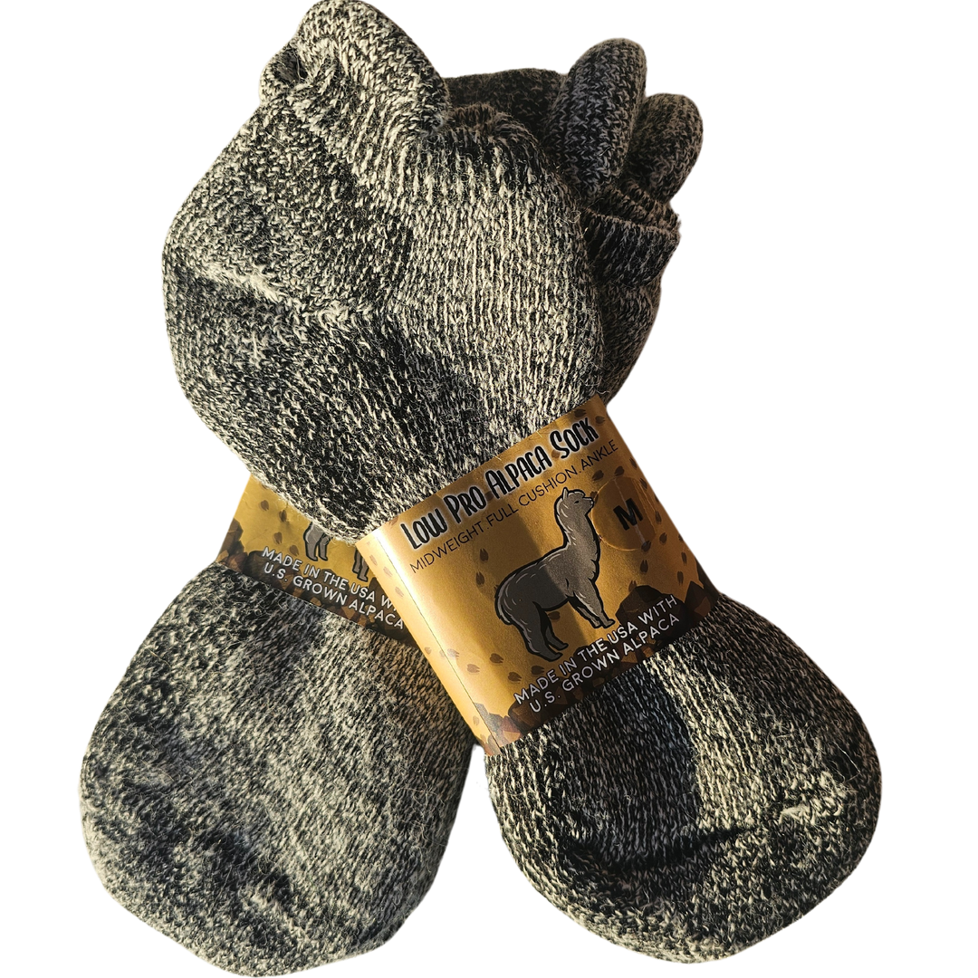 Low Pro alpaca socks displayed on a cozy knitted blanket, highlighting their soft texture and premium quality.