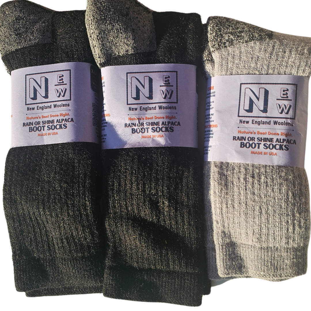 A pair of New England Woolens' Alpaca Socks displayed on a wooden table, highlighting their thick, cozy design and premium alpaca wool texture.