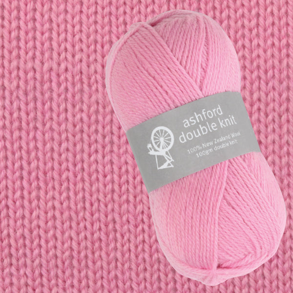 Pink yarn skein with 'ashford double knit' label on a pink knitted background
