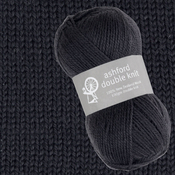Ball of black yarn with Ashford Double Knit label on a textured dark background