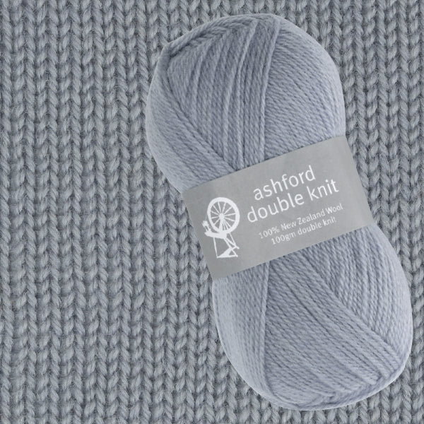 Ball of grey ashford double knit yarn on a knitted fabric background
