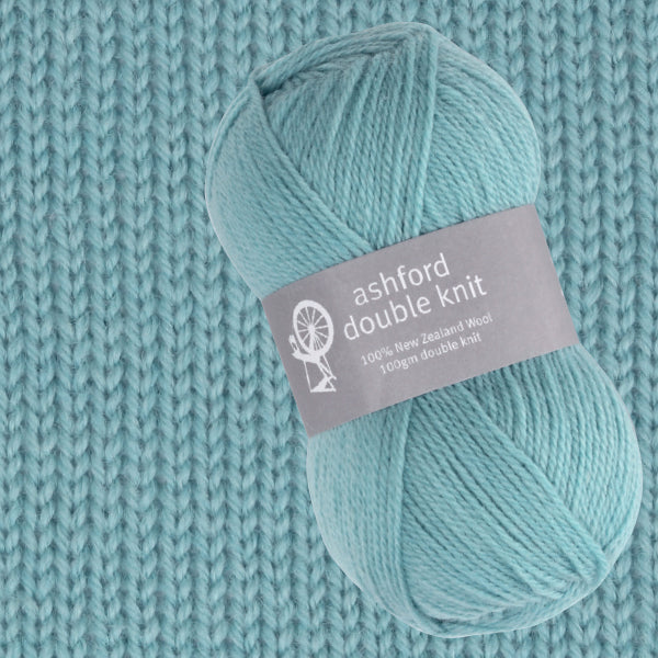 Turquoise yarn ball with Ashford Double Knit label on a knitted fabric background