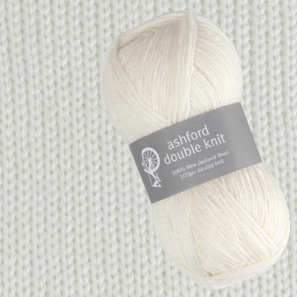 Ball of white yarn with 'ashford double knit' label on a knitted fabric background