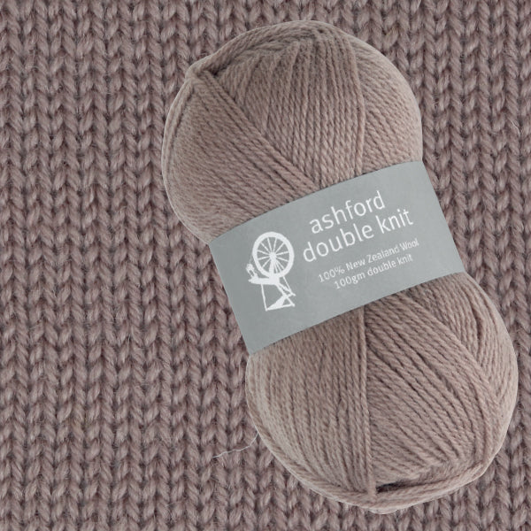 Ball of Ashford double knit yarn on a knitted fabric background