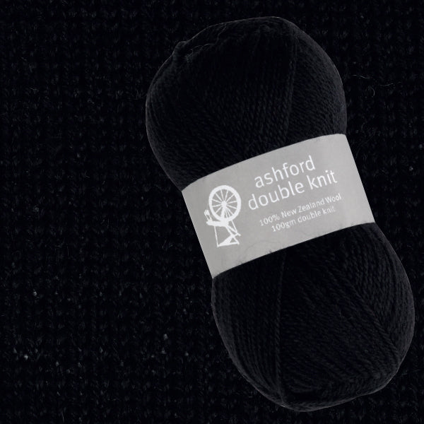 Ball of black yarn with 'ashford double knit' label on a dark background