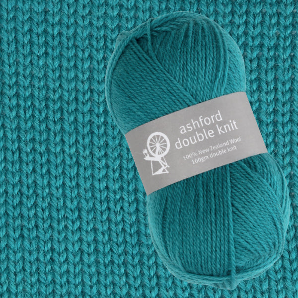 Teal skein of yarn with 'ashford double knit' label on a knitted teal background
