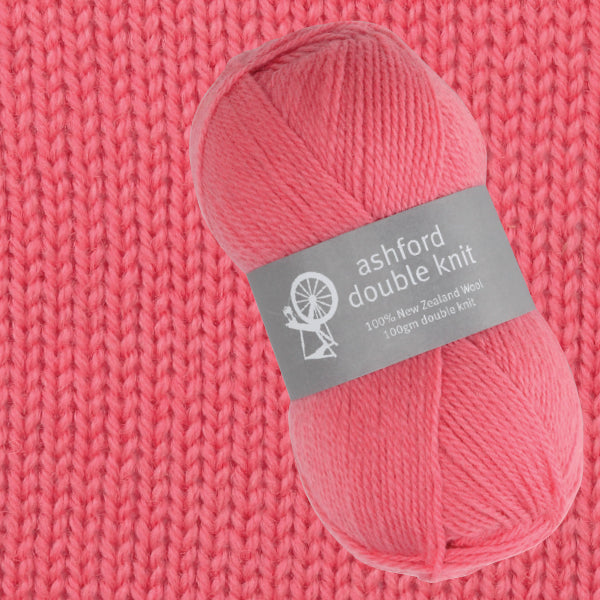 Ball of pink yarn with an Ashford Double Knit label on a pink knitted background