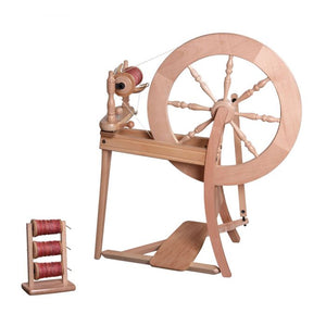 An elegant double drive spinning wheel with a high-gloss lacquered finish, reflecting exquisite craftsmanship. It boasts a large wheel with ornate spindles and a reliable foot pedal, making it a sought-after tool for professional yarn crafters and textile makers.