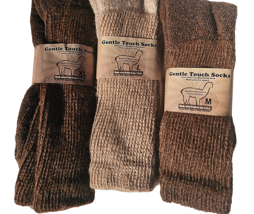 Gentle Touch wool-alpaca socks folded neatly on a rustic wooden surface, highlighting their soft, insulating fibers and timeless elegance.