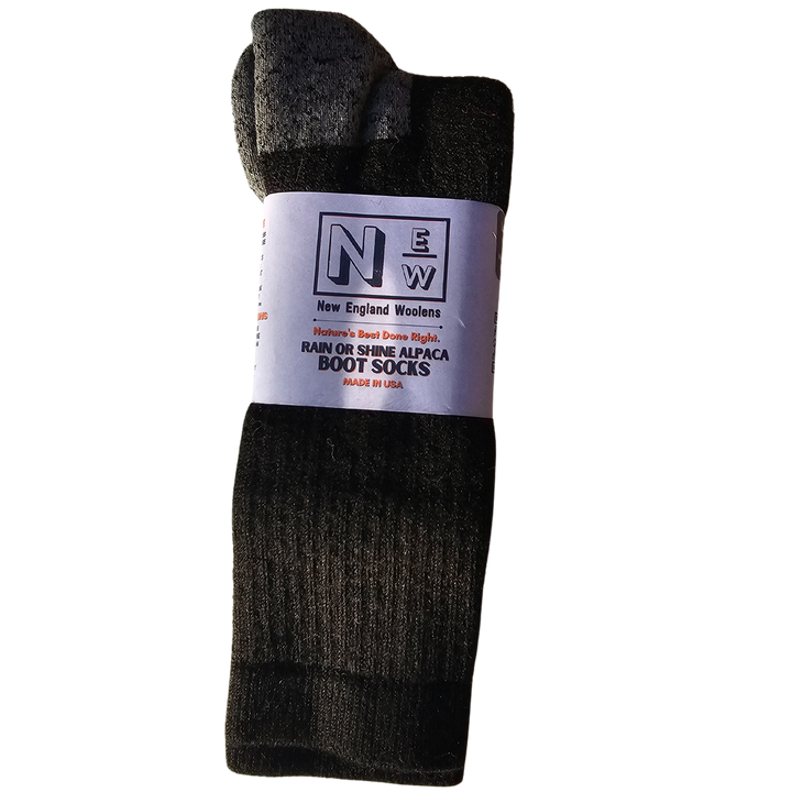 New England Woolens' Alpaca Socks folded neatly with a rustic winter backdrop, showcasing their warmth, style, and eco-friendly appeal.