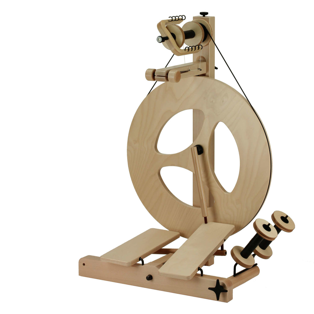 An S10 Scotch Tension Double Treadle spinning wheel with a three-spoke wheel design, showcasing a blend of classic aesthetics and modern functionality, perfect for fiber art enthusiasts.