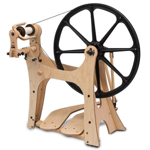 Introducing the Schacht Flatiron Spinning Wheel, a modern reinvention of the traditional Saxony-style wheel, crafted for the contemporary fiber artist. This image captures the Flatiron's sleek design and innovative features, including its black drive wheel and natural wood frame. Its customizable flyer orientation and versatile spinning capabilities make it a prime choice for artisans seeking both precision and portability.