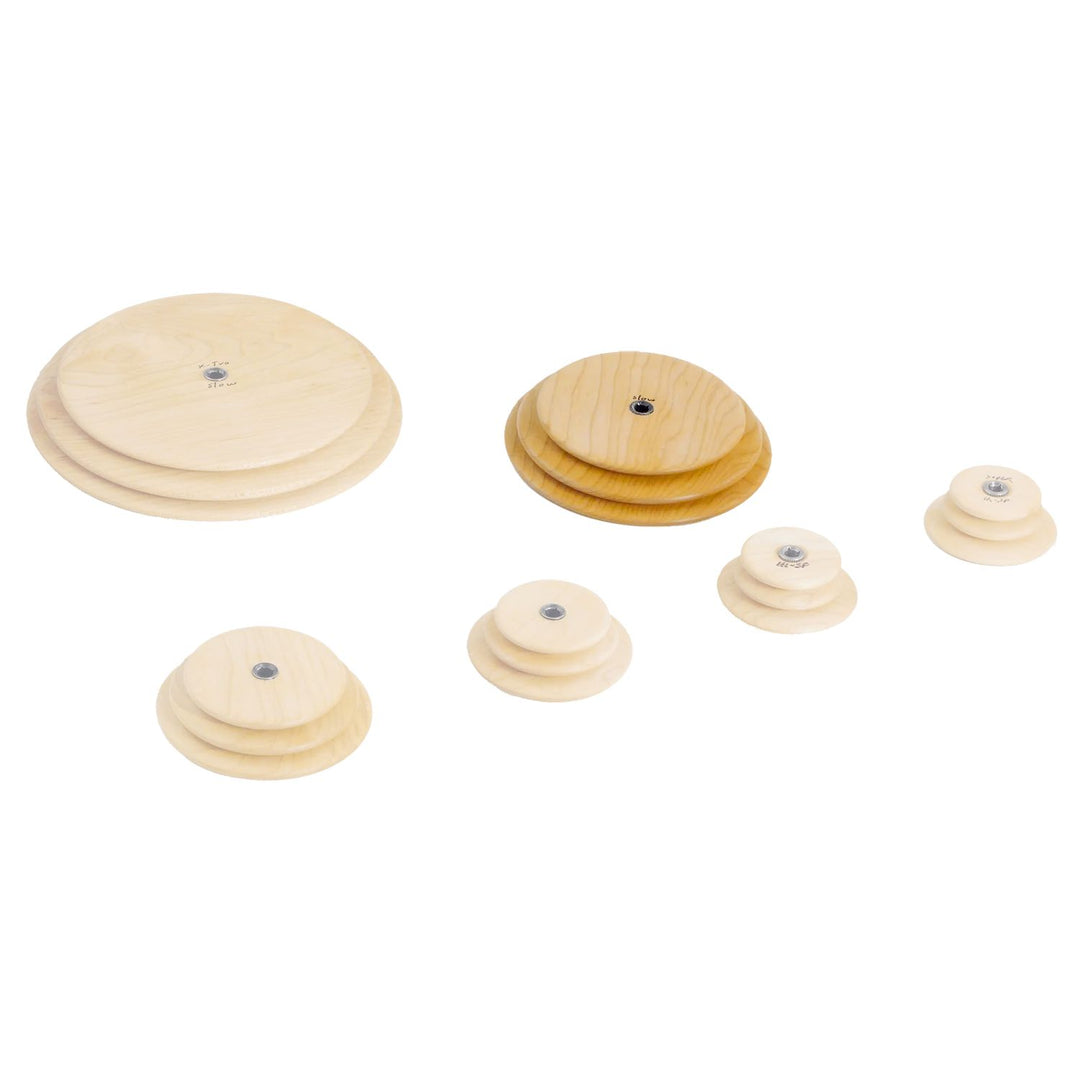 Set of wooden Schacht whorls with slow speed whorl in the foreground on a white background