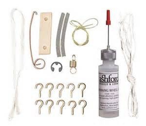 A collection of spinning wheel maintenance tools including an applicator bottle of oil, threading hooks, tension springs, flyer hooks, a footman joint, Scotch tension and brake bands, and con rod connectors.